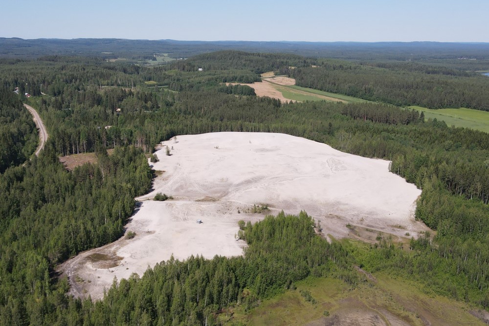 Ilmakuva valkoisesta hiekka-alueesta, jota ympäröi metsä.