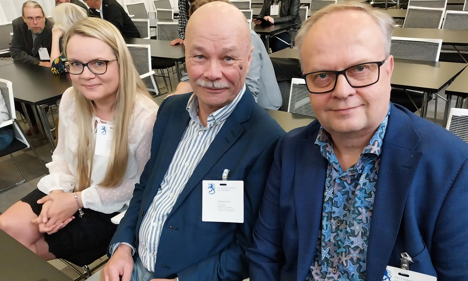 Kuvassa on kolme henkilöä.