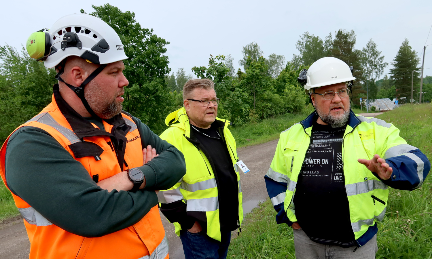Kuvassa on kolme henkilöä, joista yksi kertoo työmaasta.